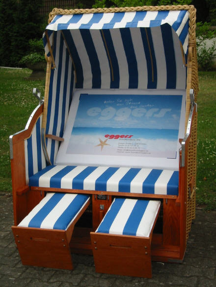 Der 2-Sitzer Strandkorb hat ein Geflecht aus PVC beige mit gestreifter Folie in blau-weiß.  Das Rückenpolster ist mit Werbung unserer Firma bedruckt.